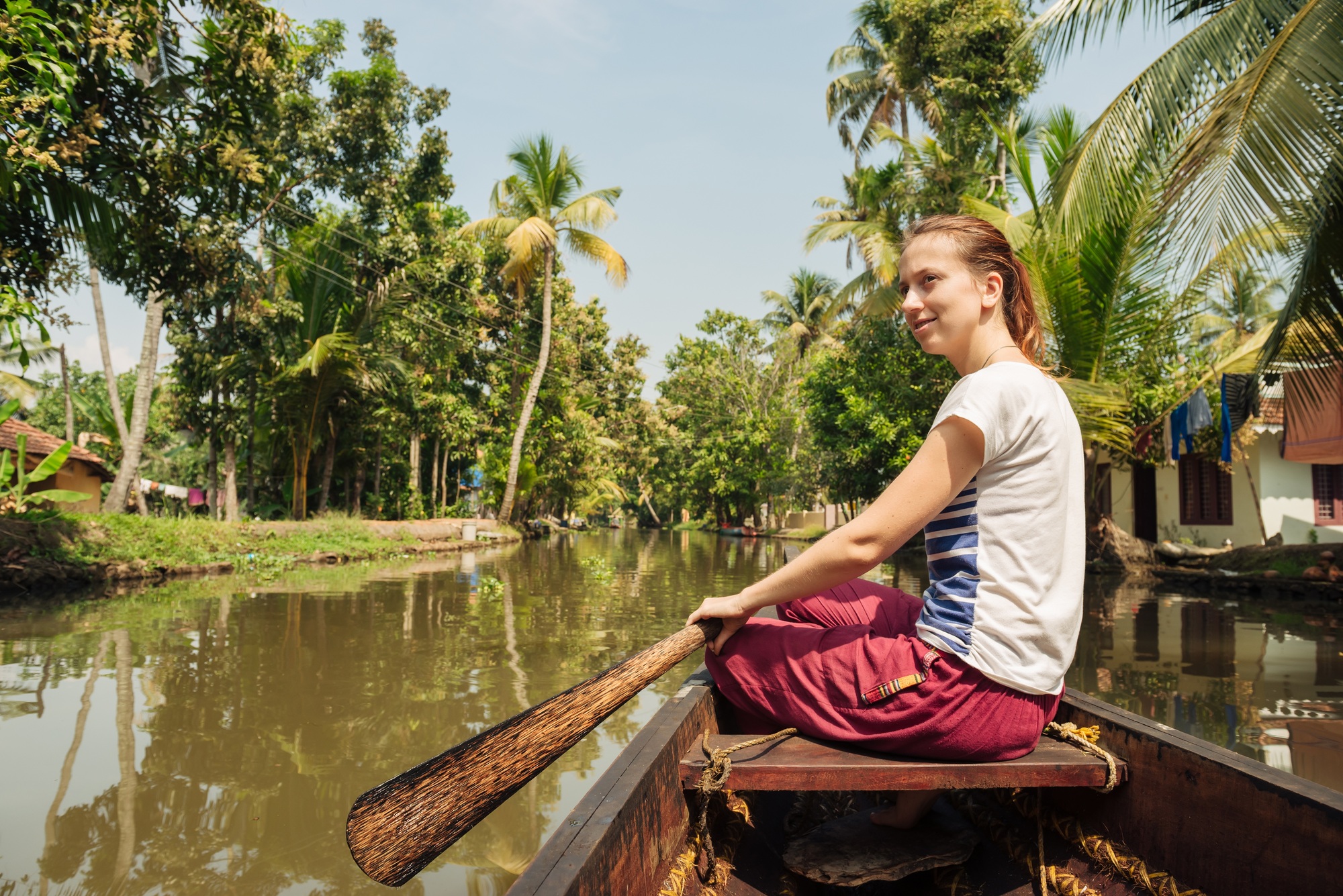 Tourist woman relaxing on Alleppey backwaters and enjoying beautiful view landscape. Kerala, India