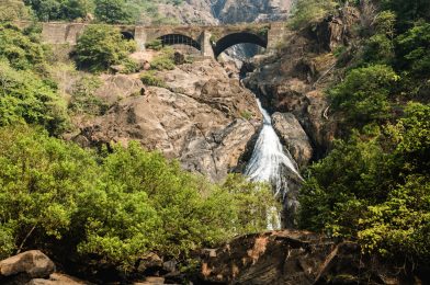 Dudhsagar waterfall and old bridge in Indian state of Goa on a sunny day
