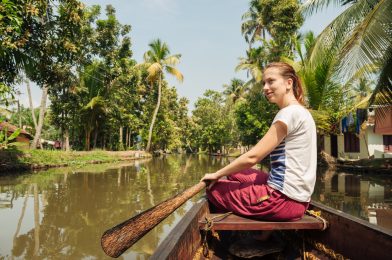 Tourist woman relaxing on Alleppey backwaters and enjoying beautiful view landscape. Kerala, India
